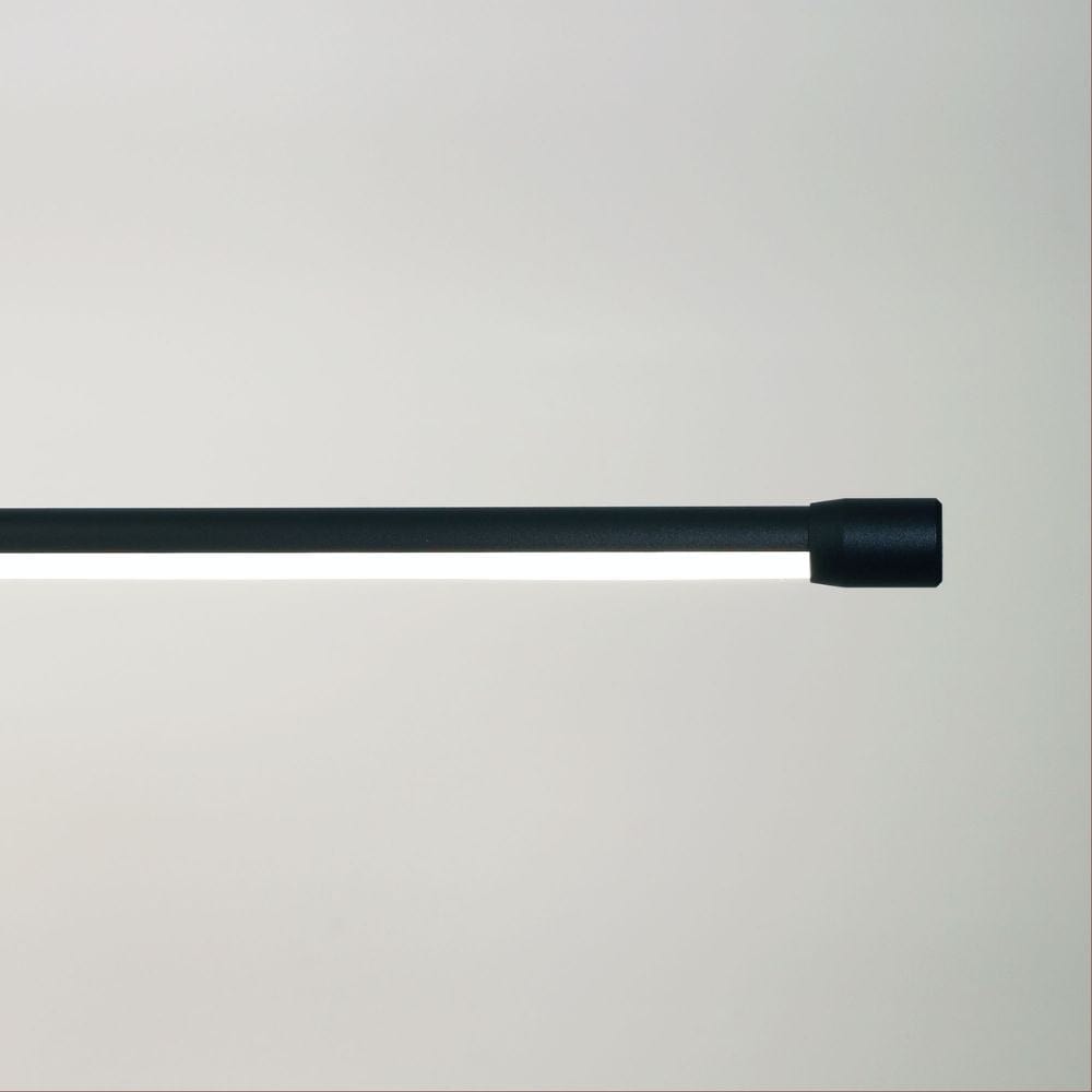 Sleek and slim black metal LED pendant hanging in a contemporary space.